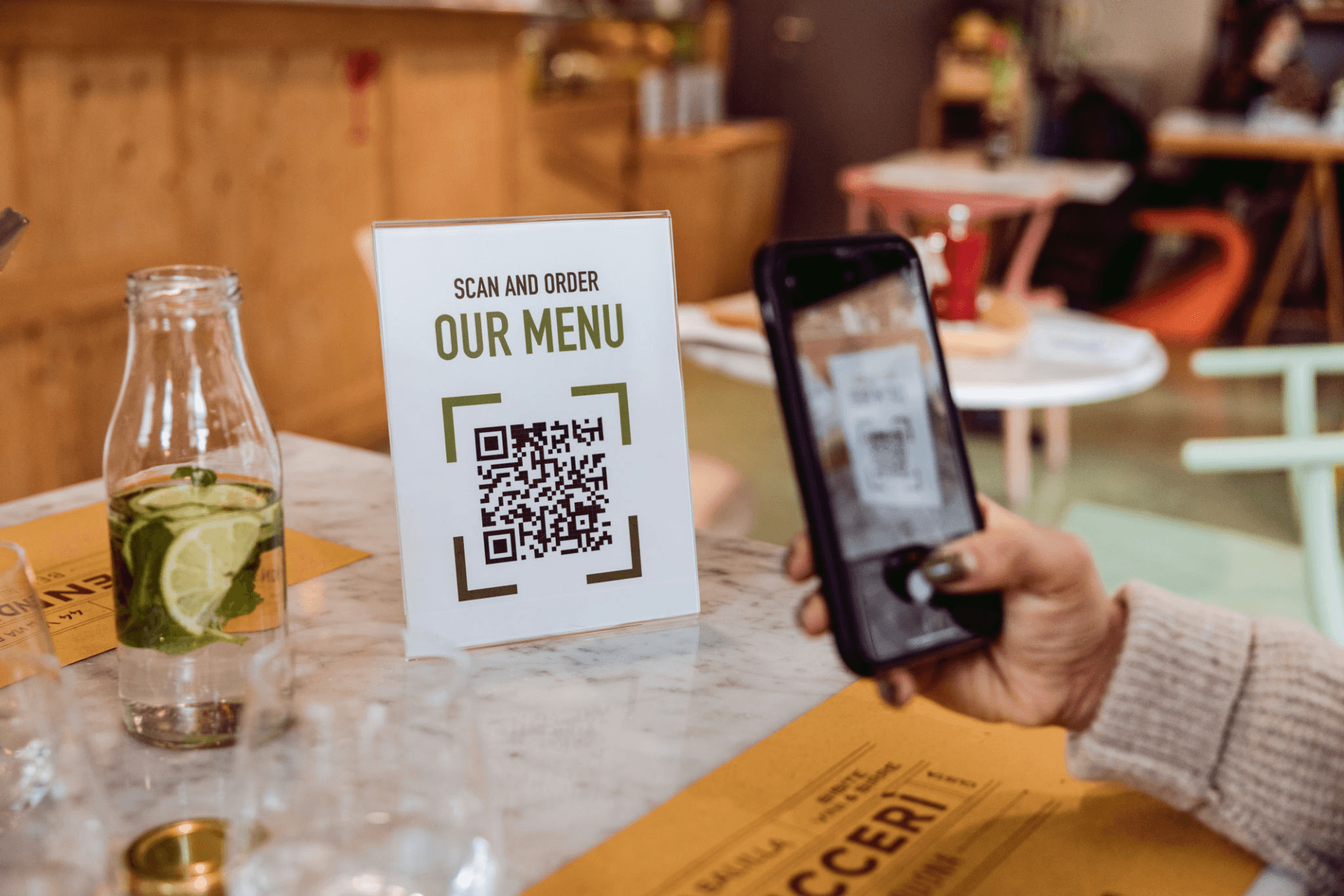 Customer scanning a Qravit QR code menu at a restaurant table